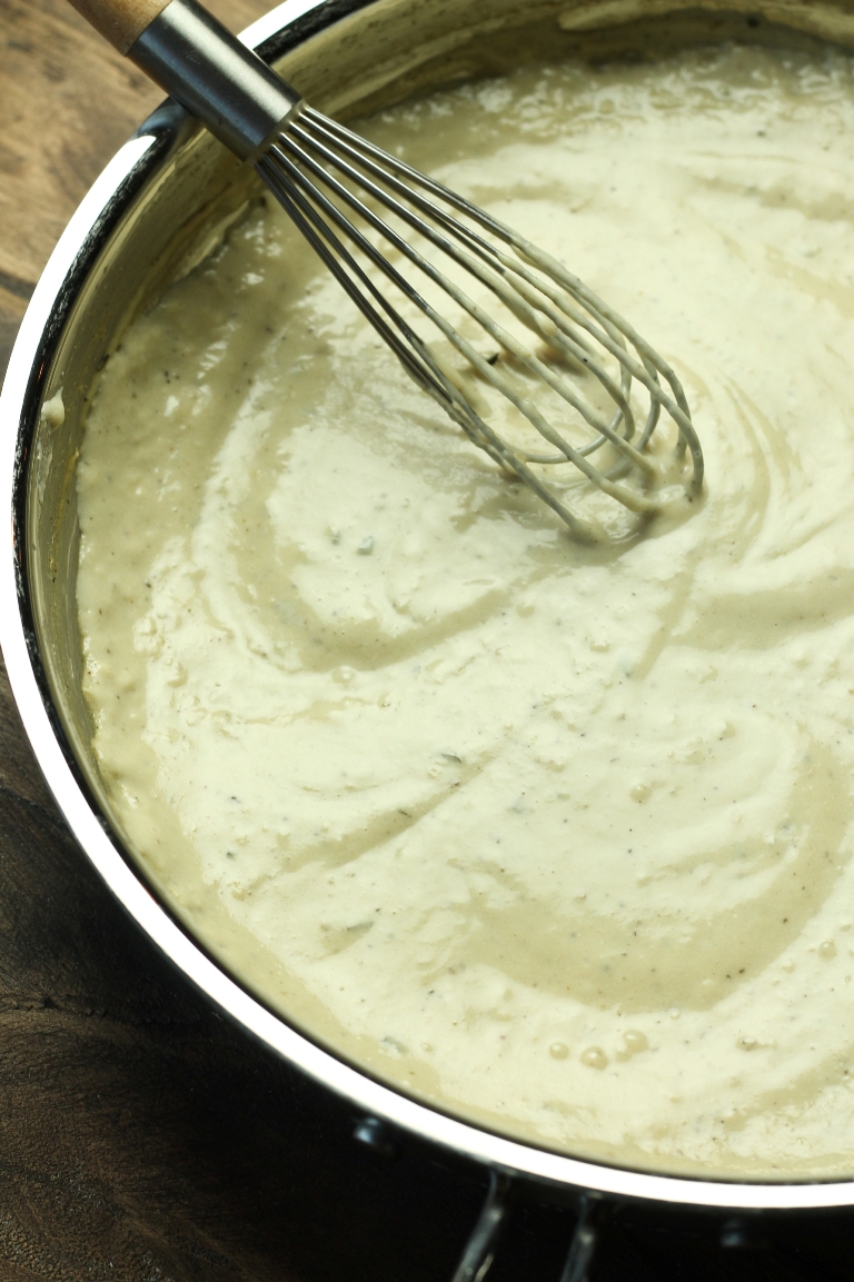 Pan of cooked creamy sauce with whisk
