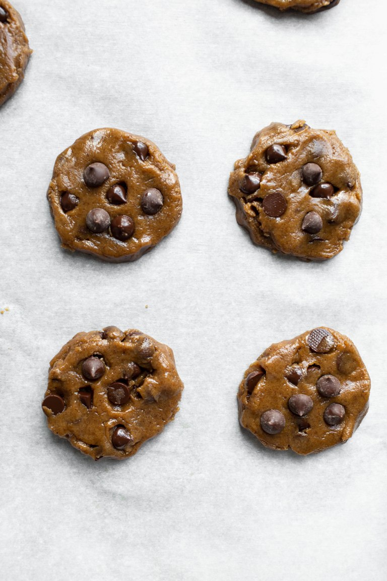Prebaked chocolate chip cookies on parchment paper