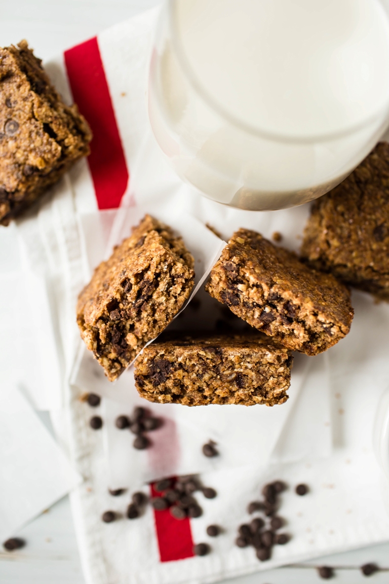 3 chocolate chip granola bars facing upward by glass of milk