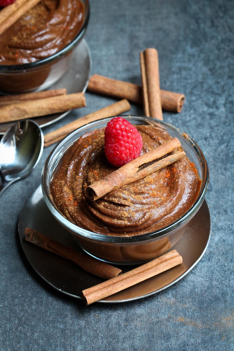 Bowl of vegan mexican chocolate sweet potato pudding with raspberry