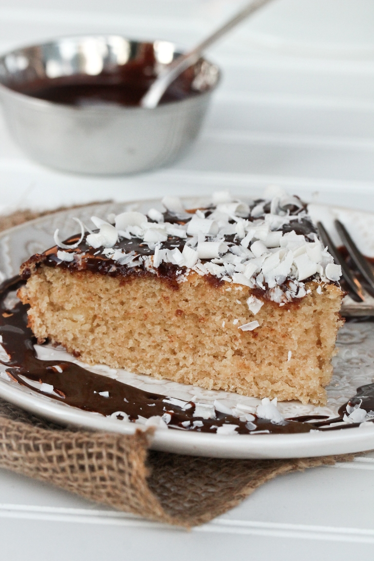 Slice of vegan gluten-free vanilla cake with chocolate ganache