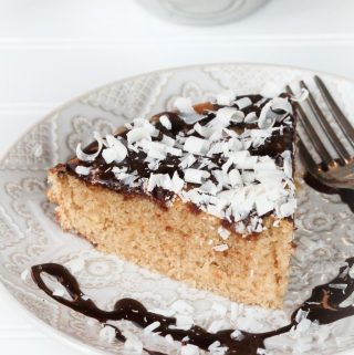 slice of vanilla cake with chocolate glaze on white plate