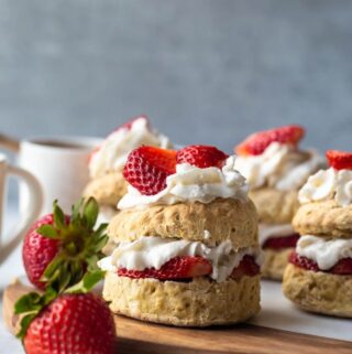 stacked shortcake with whipped cream and strawberries layers on biscuits